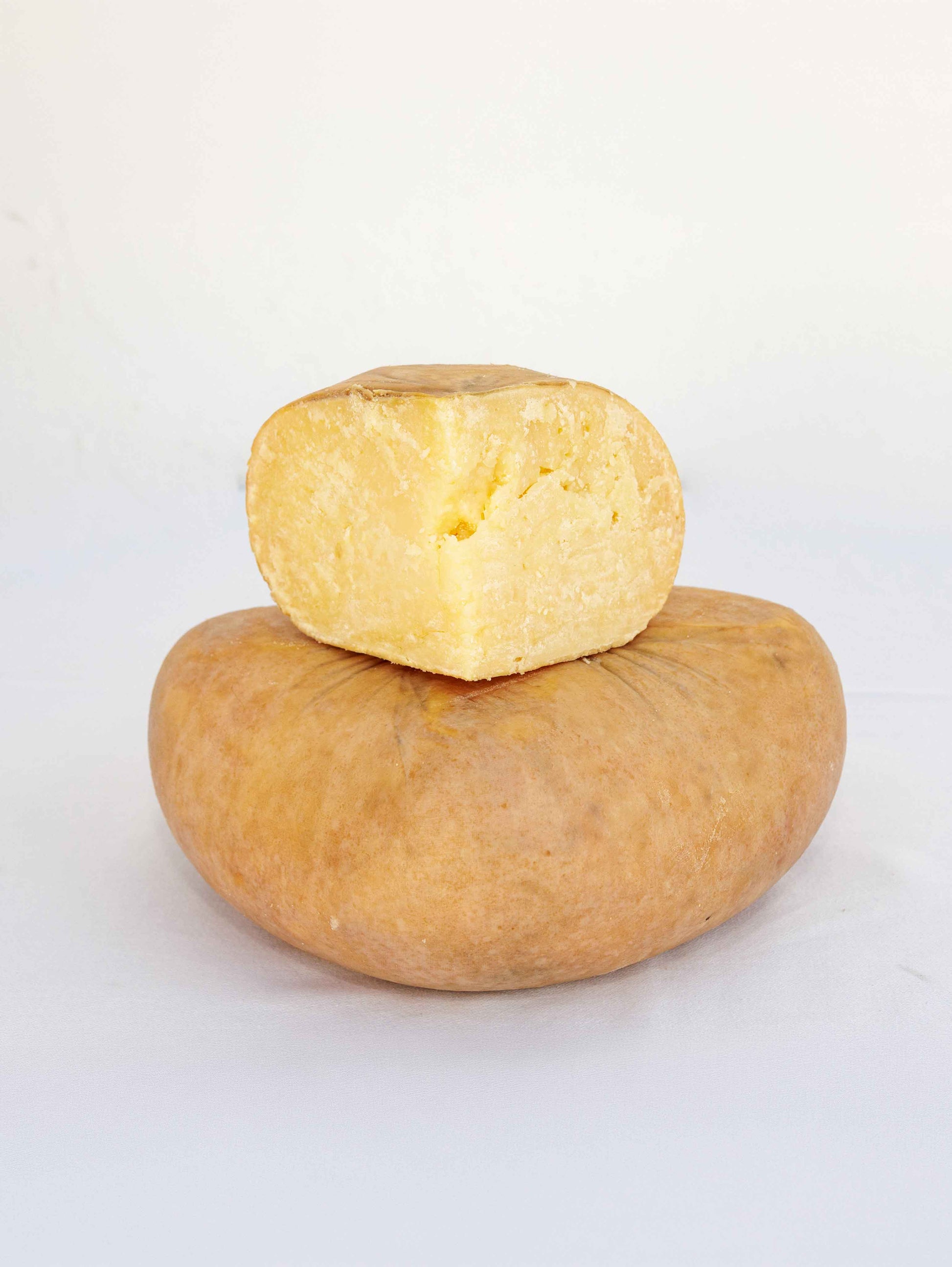 Queso curado entero con porción cortada
