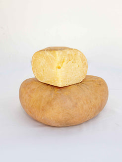 Queso curado entero con porción cortada