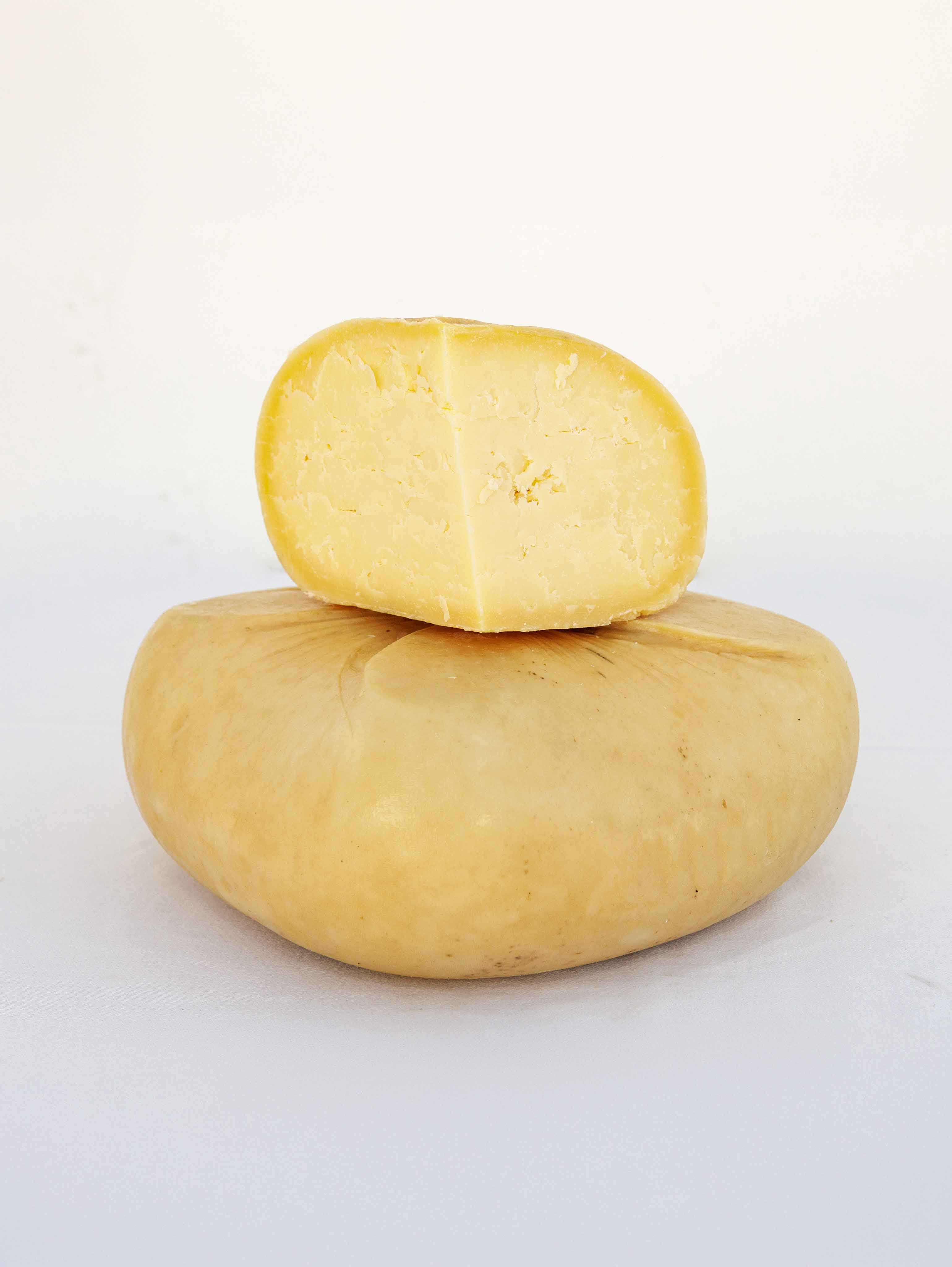 Queso semicurado entero con media pieza cortada