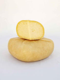 Queso semicurado entero con media pieza cortada