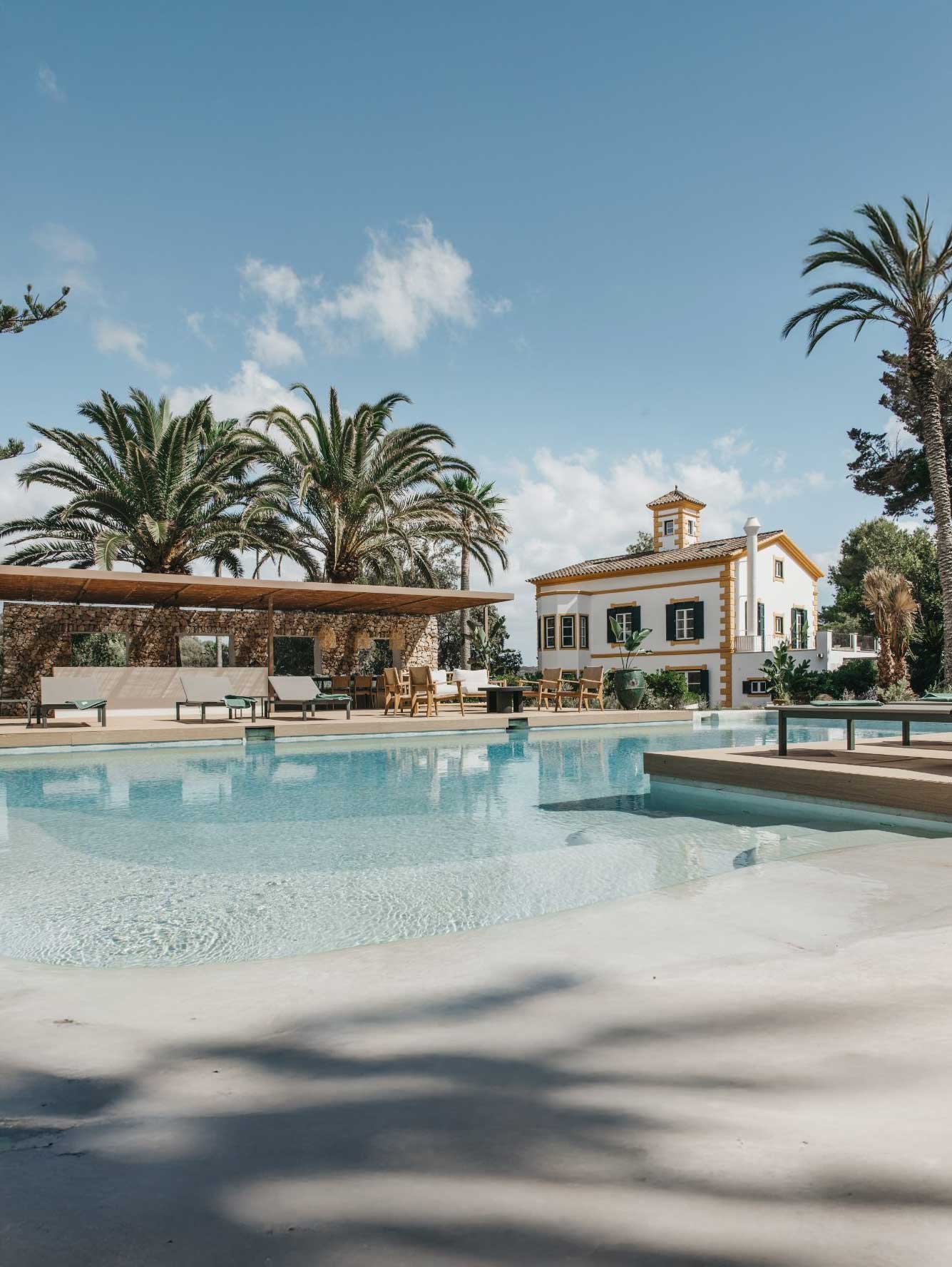 Hotel con piscina exterior y palmeras