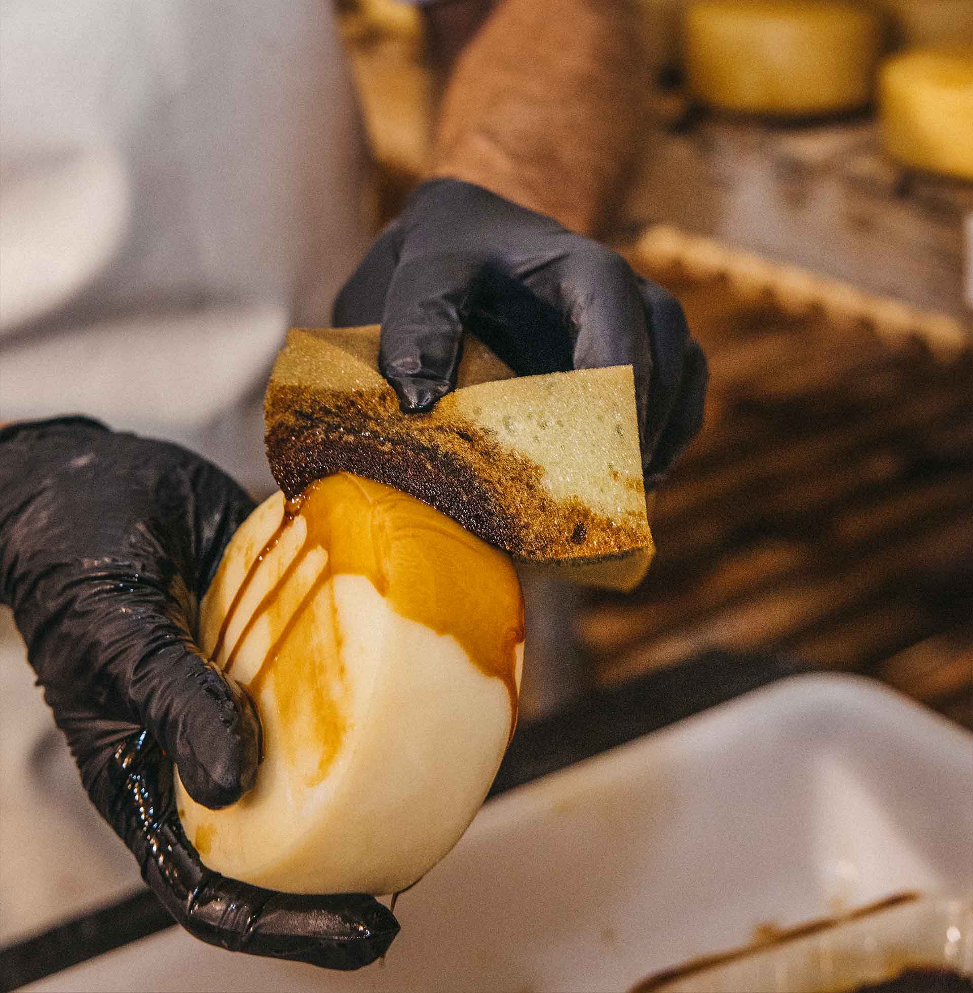 Aplicación de aceite sobre queso durante el proceso de elaboración